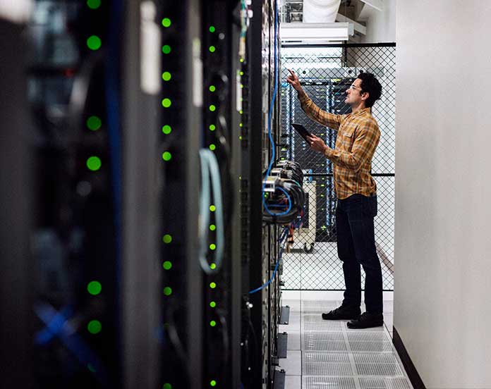 A man in a data center looking through racks