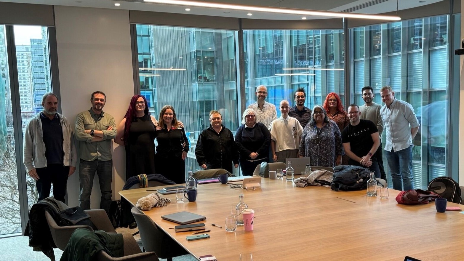 Maxime and others stand before a window in the London office