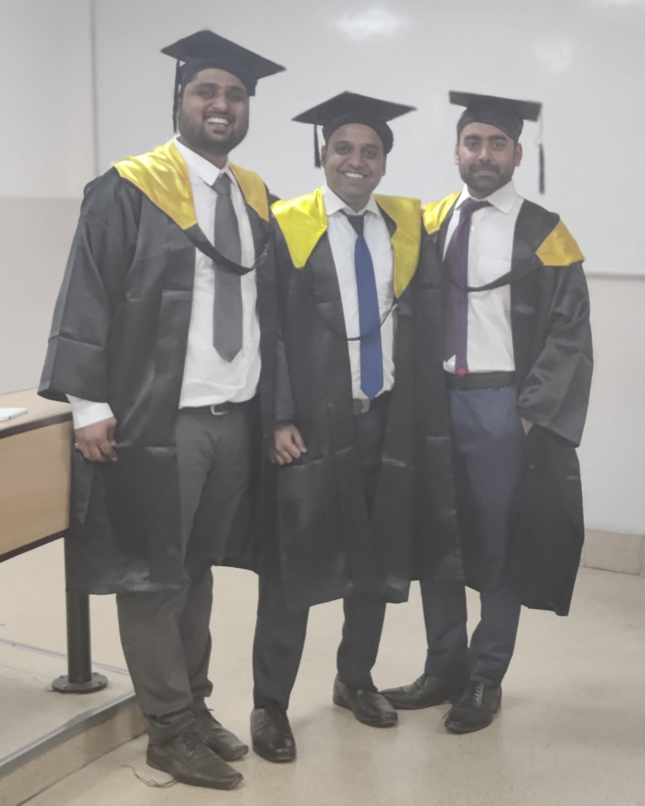 Vikram and two friends in their graduation gowns