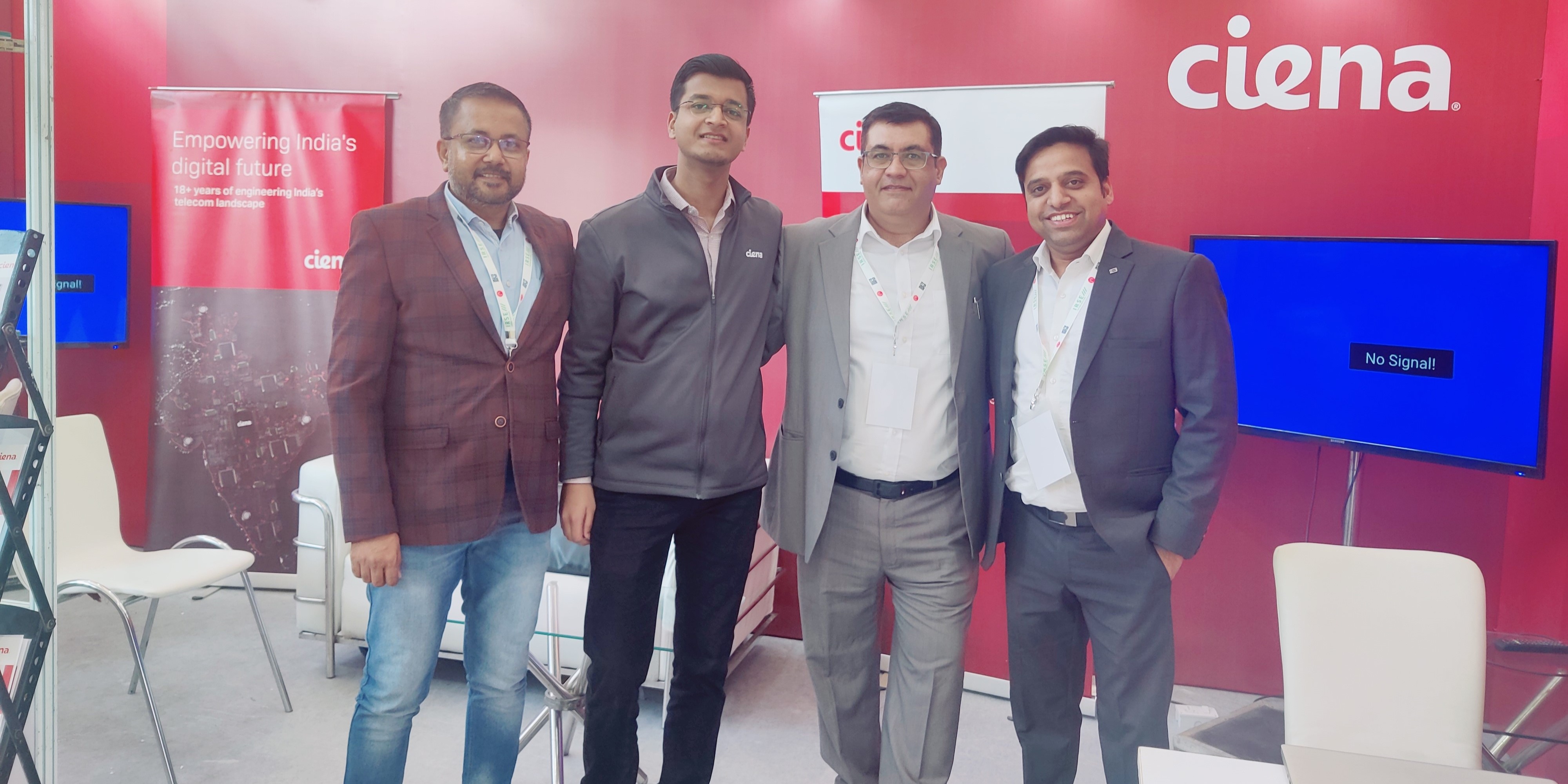 Vikram and three colleagues at Ciena booth during a trade show